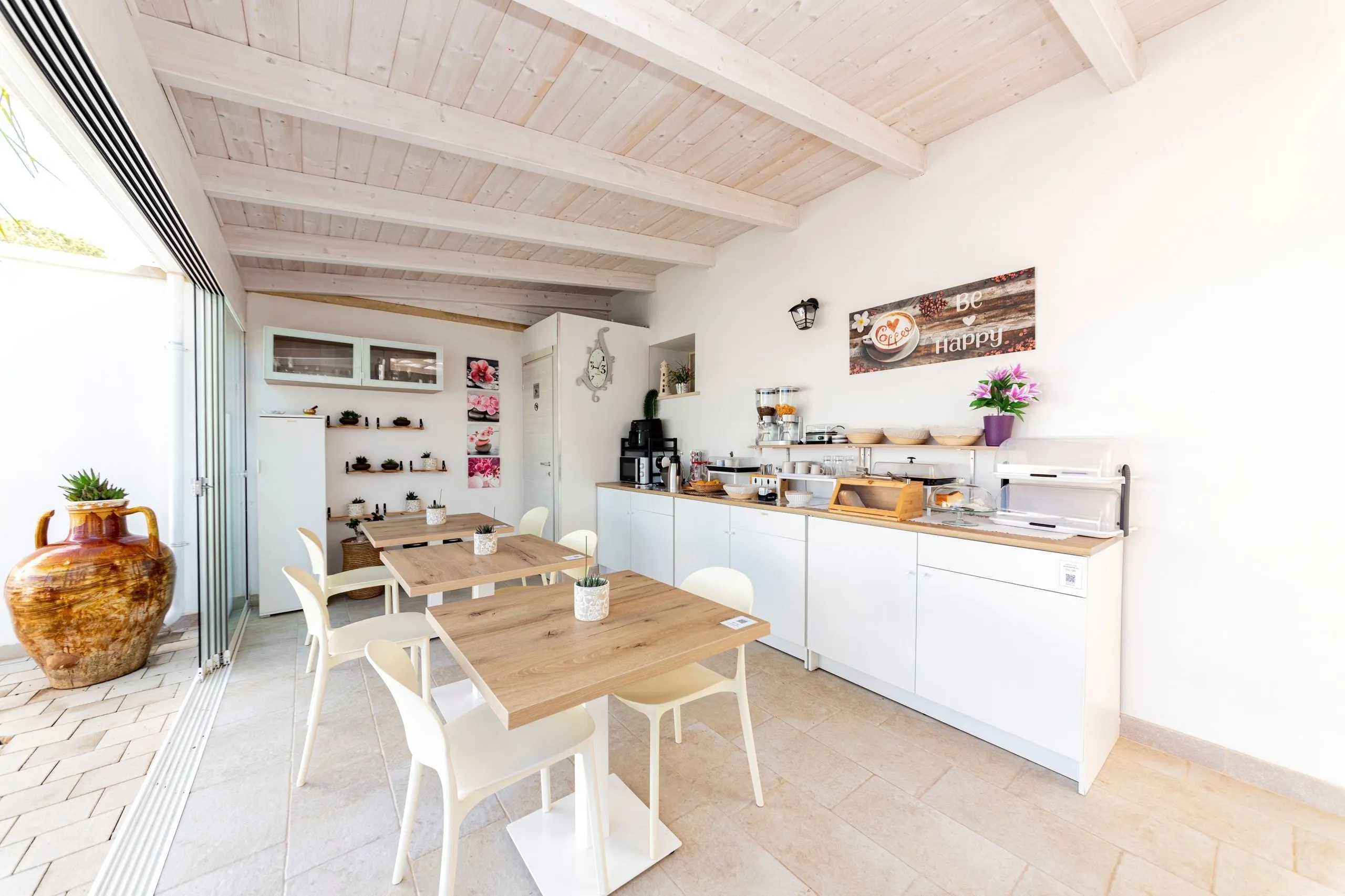 La salle du petit-déjeuner de Villa Noemi, avec son plafond en bois et la grande jarre en terre cuite