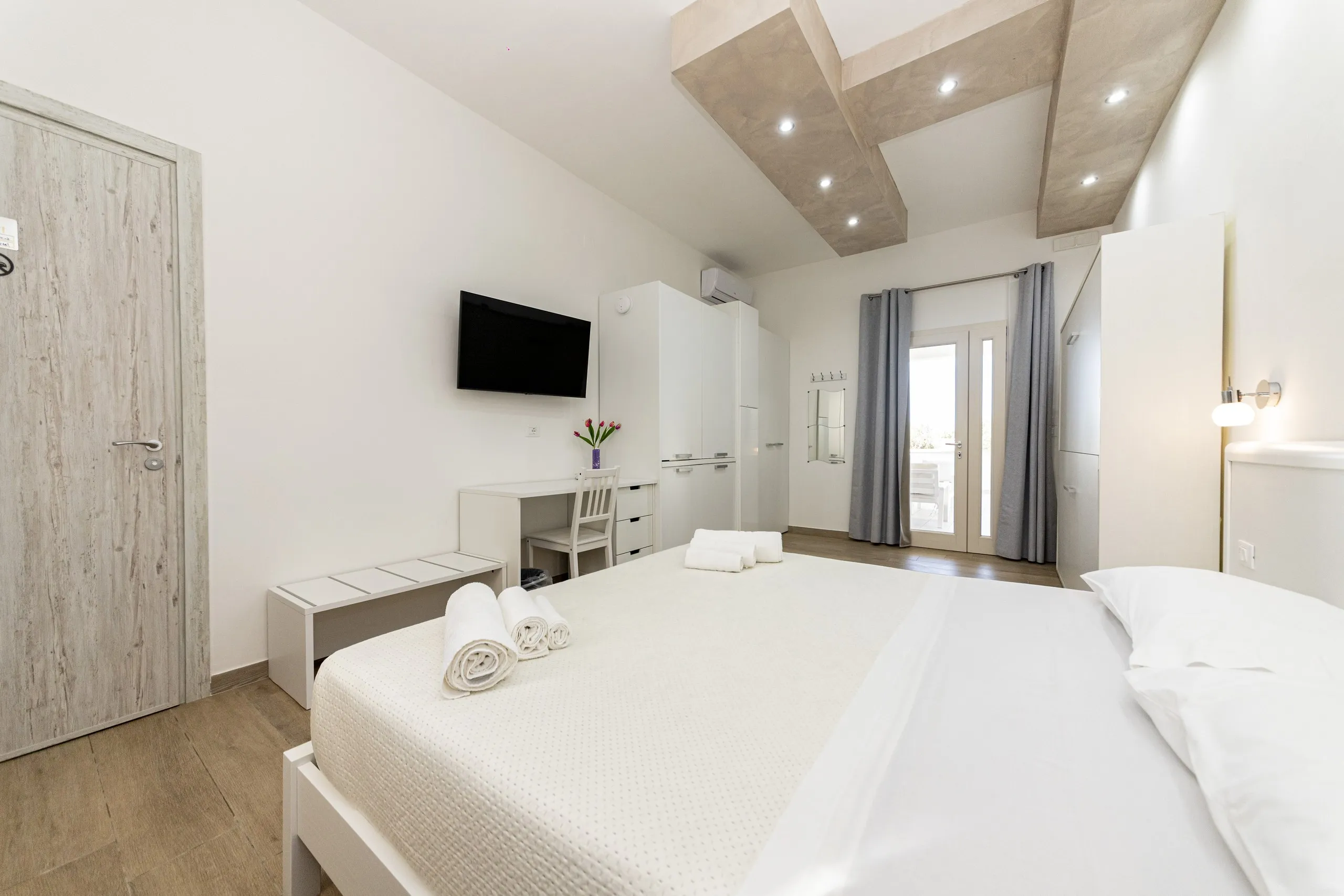 La Deluxe Family Room con il letto matrimoniale e la porta sul patio