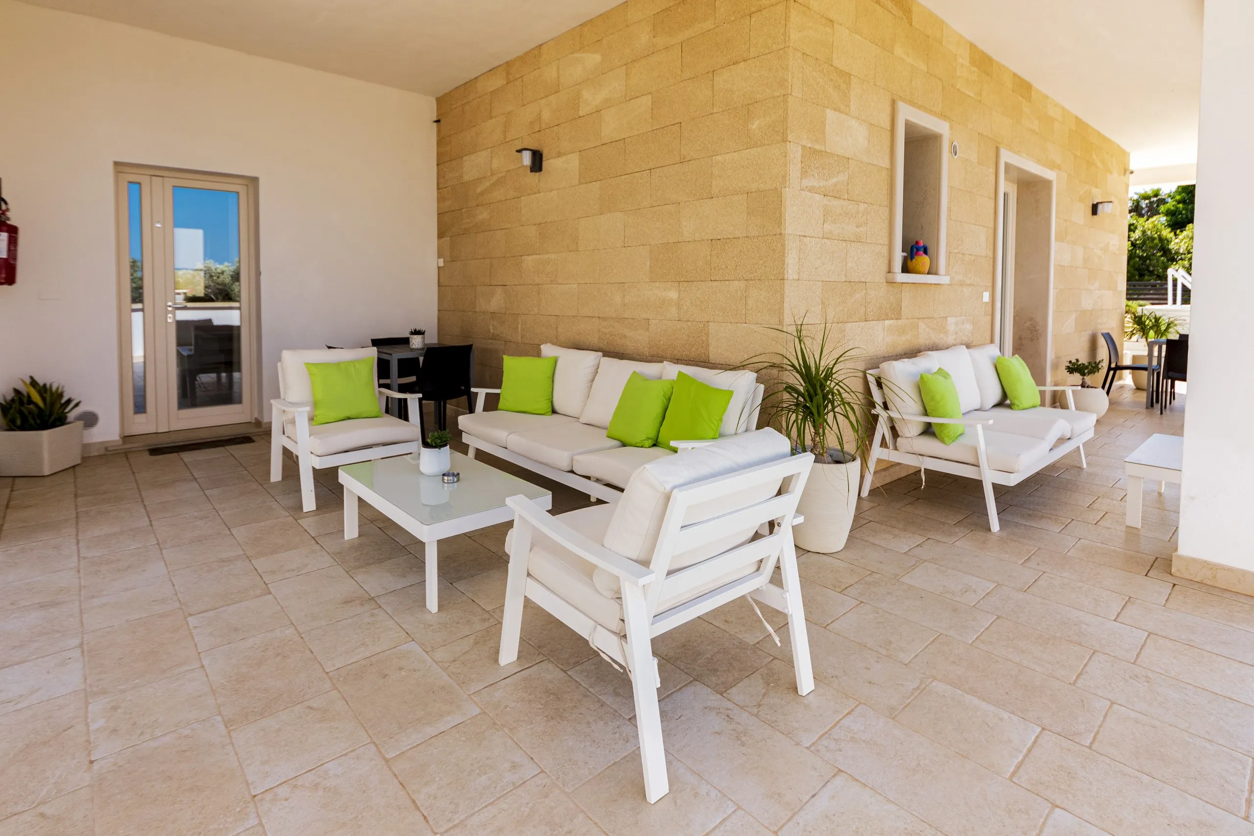 Il patio privato della Deluxe Family Room, con i divani e il muro in pietra leccese