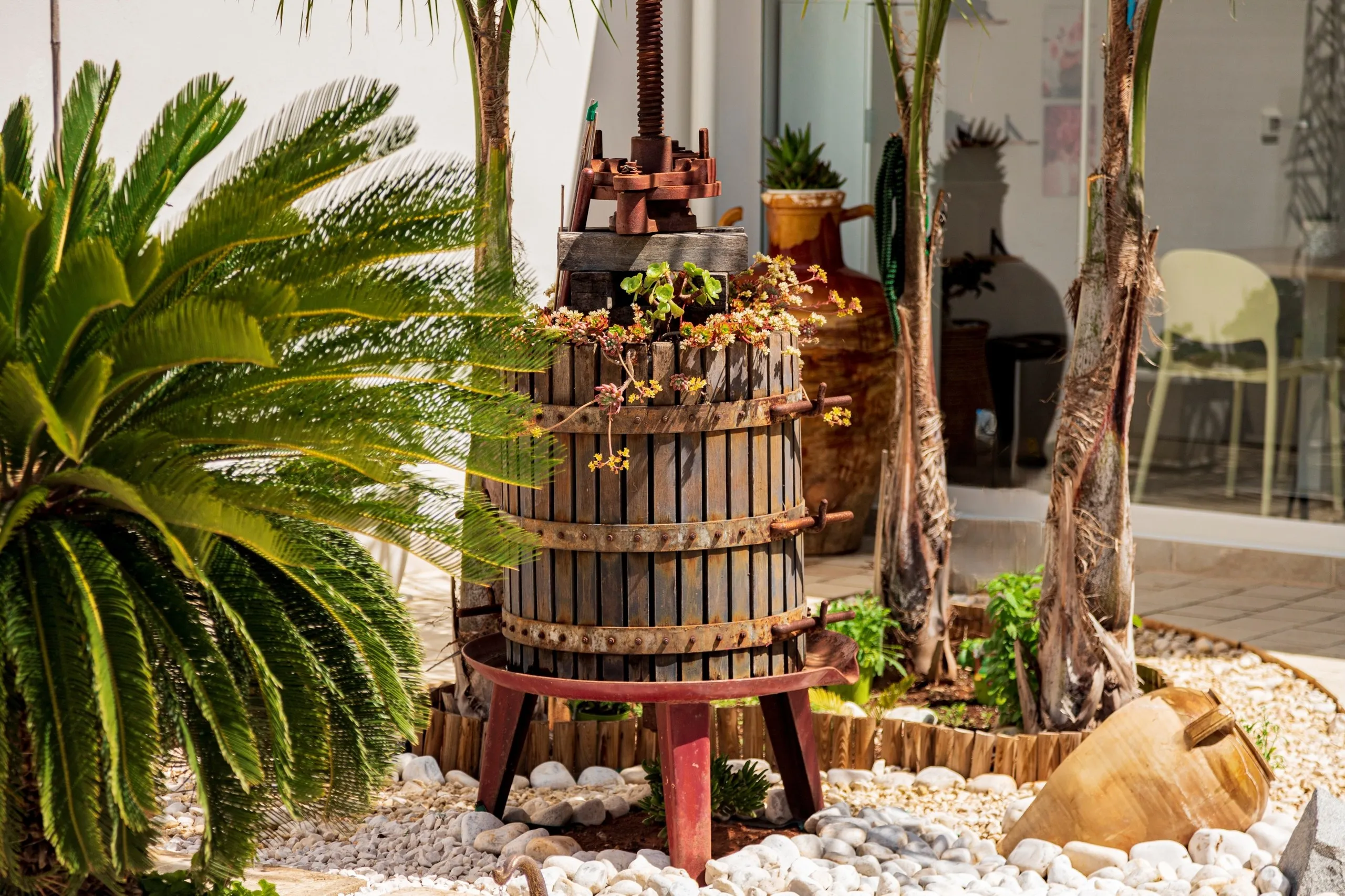 Il torchio d’epoca conservato fra le palme del giardino