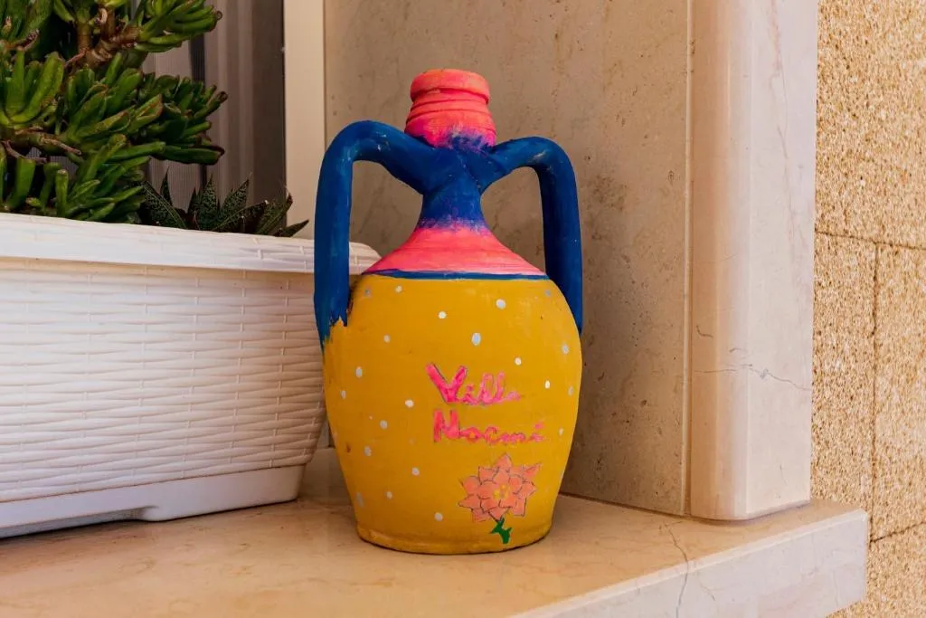 Un orcio giallo dipinto a mano con la scritta “Villa Noemi”