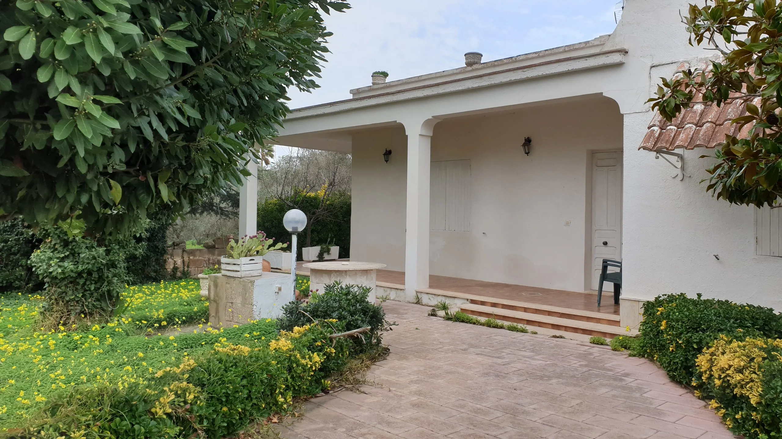 La villa nel 2021, prima dei lavori: il portico e il giardino ancora da sistemare